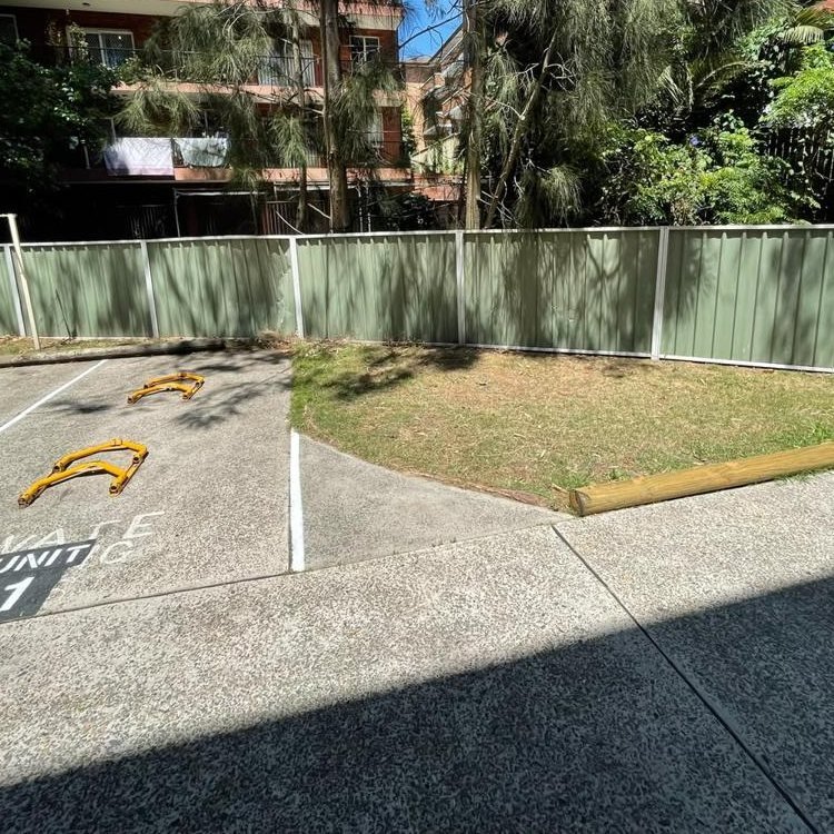 The green Colorbond fence after the dented sheets were replaced