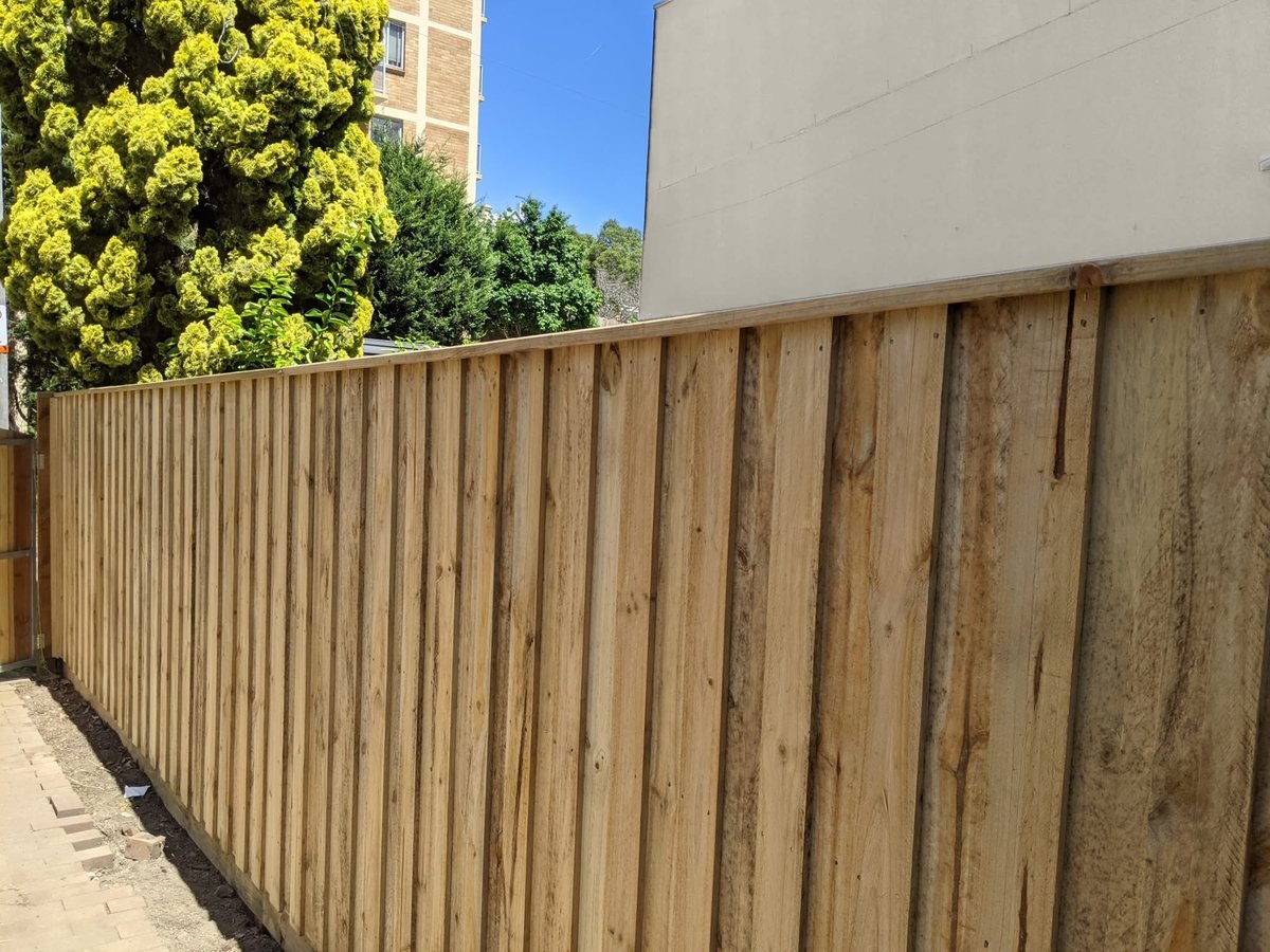 New lapped timber paling fence along a side path